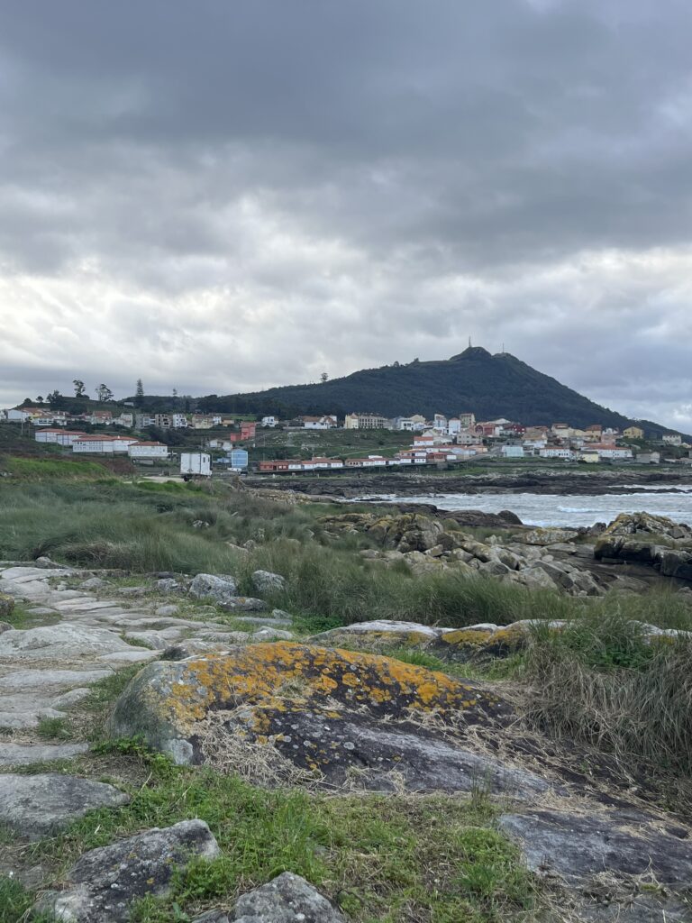 Femeie pe Camino, am lăsat A Guarda în spate avansând pe malul oceanului cu margini stâncoase